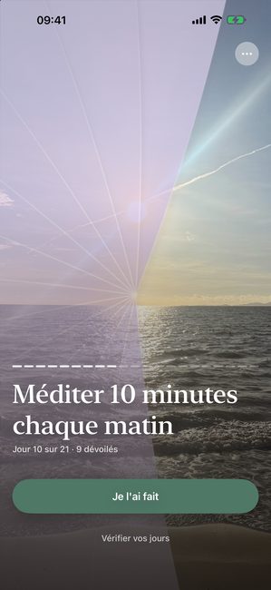 L'application affichant une photo de coucher de soleil partiellement dévoilée avec un voile violet, au jour 10 d'un parcours de méditation de vingt et un jours.