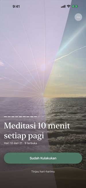 Aplikasi menampilkan foto matahari terbenam yang sebagian terbuka dengan penutup ungu, pada hari ke-10 dari perjalanan meditasi dua puluh satu hari.
