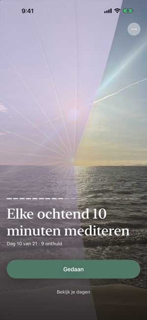 De app met een zonsondergangfoto die deels onthuld is met een paarse afdekking, op dag 10 van een meditatiereis van eenentwintig dagen.