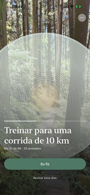 O app mostrando uma foto de floresta parcialmente revelada em anéis concêntricos, no dia 27 de uma jornada de corrida de sessenta e seis dias.