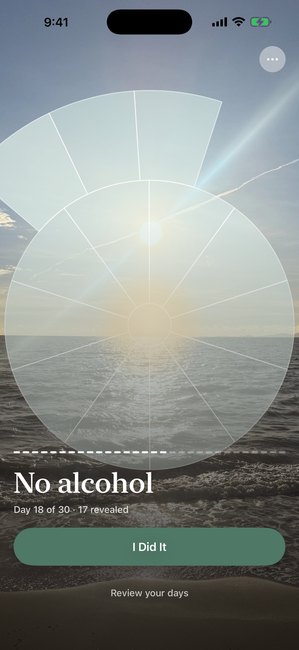 The app showing a photo of the sea partly uncovered in arc segments, on day 18 of a thirty day journey without alcohol.
